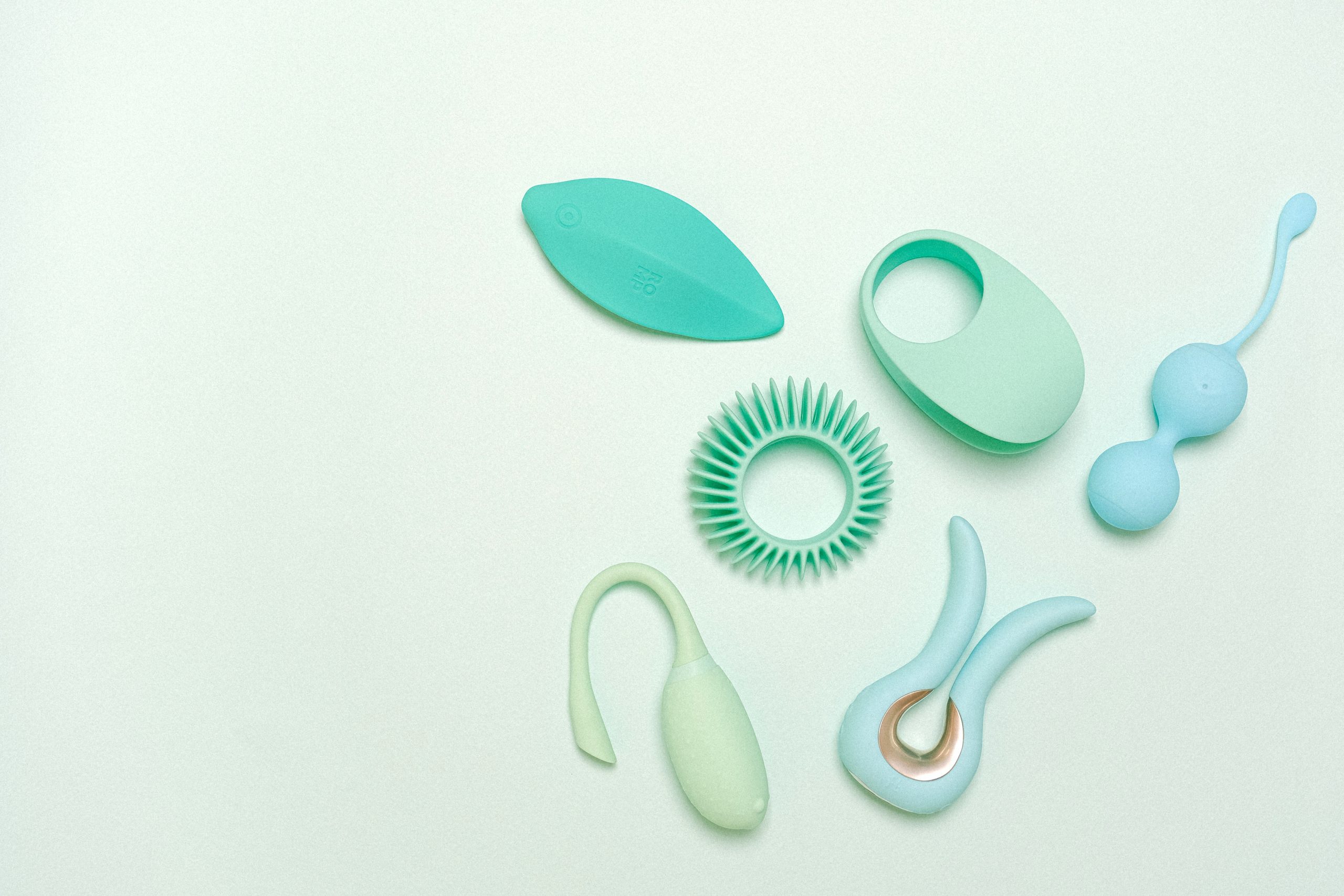 Some light green & blue toys against a mint green background.